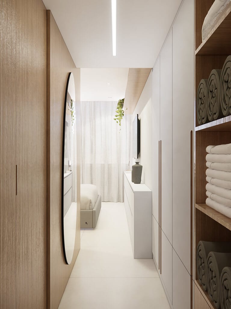 Um quarto moderno e minimalista com acabamentos em madeira clara e branco, um grande espelho oval, prateleiras abertas com toalhas enroladas, uma cama com cortinas transparentes e uma pequena TV em um elegante armário branco com uma planta em vaso.